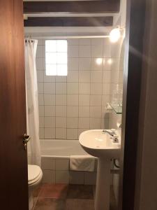 a bathroom with a sink and a tub and a toilet at HOSTERÍA SAJONIA in Villa Gesell