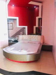 a large bed in a room with a red wall at Euro Motel (Only Adults) in Viracopos