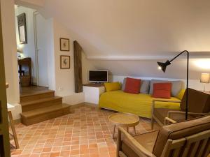 - un salon avec un canapé jaune et une télévision dans l'établissement Le Domaine de Belleville, à Dragey-Ronthon