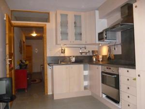 eine kleine Küche mit weißen Schränken und einer Spüle in der Unterkunft Zimmer Frei in Wiesbaden