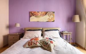 1 Schlafzimmer mit lila Wänden und 1 Bett mit 2 Kissen in der Unterkunft In Arezzo Apartment in Arezzo