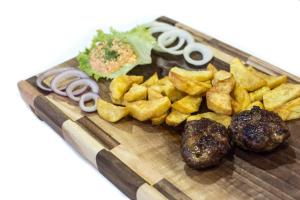 une assiette de nourriture avec des pommes de terre et d’autres denrées alimentaires dans l'établissement Bed and Breakfast Turist, à Staro Petrovo Selo