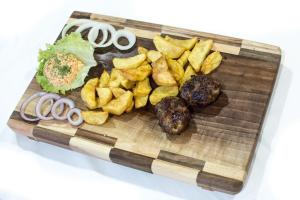 um prato de alimentos com batatas fritas e outros alimentos em Bed and Breakfast Turist em Staro Petrovo Selo