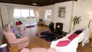 a living room with two couches and a fireplace at Three bedroom holiday home in Port