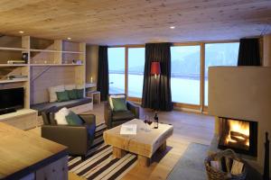 ein Wohnzimmer mit Kamin, Sofa und Tisch in der Unterkunft BöckLodges in Nesselwang