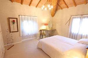 een slaapkamer met een wit bed, een tafel en een raam bij Il Bozzolo Eco Boutique Apartments in Valeggio sul Mincio