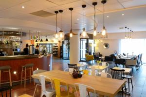 a restaurant with tables and chairs and a bar at Novotel Suites Rouen Normandie in Rouen