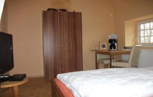 1 dormitorio con 1 cama y escritorio con mesa en Landhaus-Nordseekueste en Jethausen