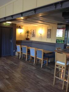 a bar with blue chairs in a restaurant at The Bear On The Square in Millom