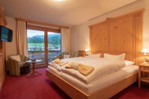 ein Schlafzimmer mit einem großen Bett und einem großen Fenster in der Unterkunft Haus Melitta in Lech am Arlberg