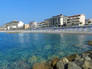 a beach with a large body of water at Hotel Il Mulino in Capo dʼOrlando