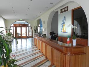 a woman sitting at a counter in a hotel lobby at Hotel Il Mulino in Capo dʼOrlando