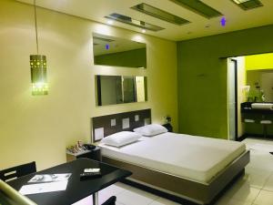 a bedroom with a bed and a table and a bathroom at Euro Motel (Only Adults) in Viracopos