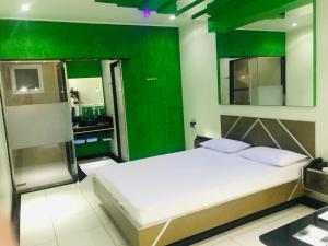 a bedroom with a bed and a green wall at Euro Motel (Only Adults) in Viracopos