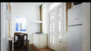 una cucina con tavolo, sedia e porta di Beograd Admiral Apartments a Belgrado