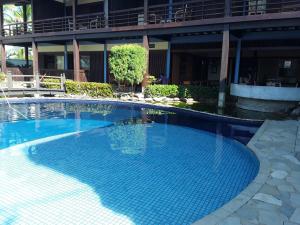 a large blue swimming pool in front of a building at Charme Hotel Guarujá Frente Mar in Guarujá