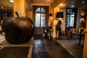 an apple statue sitting on a counter in a room at The Originals Boutique, La Maison Rouge, Lens Ouest (Qualys-Hotel) in Noeux-les-Mines