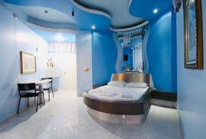 a blue room with a bed and a table at Euro Motel (Only Adults) in Viracopos