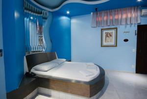 a bedroom with a bed in a blue room at Euro Motel (Only Adults) in Viracopos