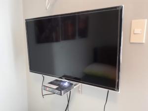 Μια τηλεόραση ή/και κέντρο ψυχαγωγίας στο 1BR with Balcony Overlooking Pool Chateau Elysee Near NAIA