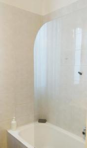 a white bathroom with a tub and a window at Holiday Home Bergamo 1 in Bergamo