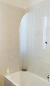 Un baño blanco con bañera y ventana. en Holiday Home Bergamo 1, en Bérgamo 19 fotos más