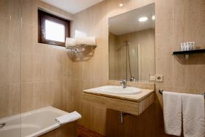a bathroom with a sink and a tub and a mirror at Ikonik Plaza Mercado in Salamanca +27 photos