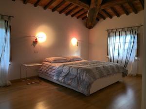 een slaapkamer met een groot bed en 2 ramen bij Casa Cinzia in Castellina in Chianti