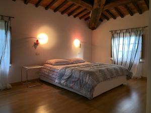 a bedroom with a large bed with two windows at Casa Cinzia in Castellina in Chianti