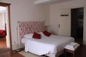 ヴェズレーにあるCellier de l'abbaye - L'Ermitageのベッドルーム(赤い枕の大きな白いベッド付)