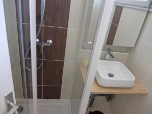 y baño con ducha y lavamanos. en Holiday Home Hameau des Pins, en Cap d'Agde