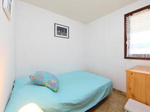 a small bedroom with a blue bed and a window at Apartment Les Estivales in Cap d'Agde