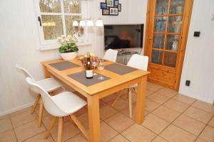 a dining room with a wooden table and white chairs at Blockhaus _ ideal bis 4 Personen in Damp