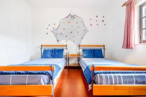 アルトゥーラにあるAltura Inn Cottageのベッド2台 壁に傘が備わる客室です。