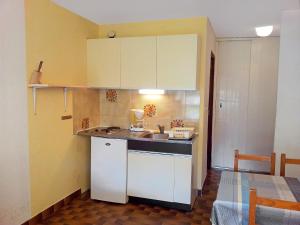 a small kitchen with white cabinets and a sink at Apartment Mykonos-1 by Interhome in Port Leucate