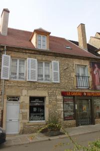 an old stone building with white shutters on it at Cellier de l'abbaye - L'Ermitage in Vézelay