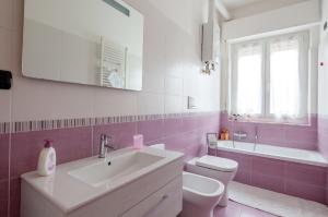 a pink and white bathroom with a sink and a toilet at Rebecca House in La Spezia