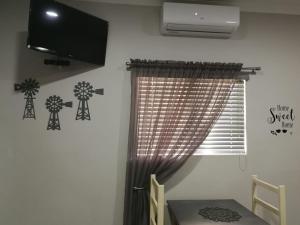 a room with a window with a tv and a curtain at Kalahari Rus in Upington