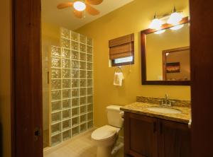 a bathroom with a toilet and a sink and a mirror at X'tan Ha- The Waterfront in San Pedro