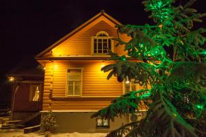 a house with a tree in front of it at U Pokrovki Guest House in Pskov