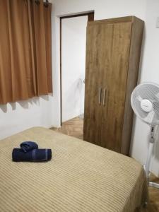 1 dormitorio con 1 cama y armario de madera en Casa en Alquiler, en Piriápolis