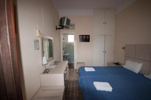 a bedroom with a blue bed and a sink at Avaton Hotel in Lygourio