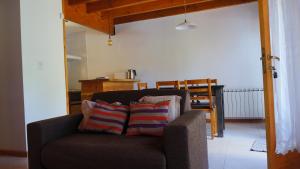 1 sofá con 2 almohadas en la sala de estar en ROSALES Alojamiento en Villa La Angostura