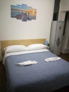 a bedroom with a bed with two towels on it at Guest house ELENA in Genoa