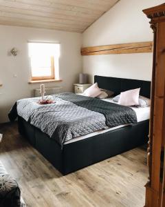 a bedroom with a large bed with a wooden floor at Ferienwohnung Auszeit in Ausnang in Leutkirch im Allgäu