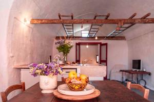 a table with a bowl of fruit and a vase of flowers at Masseria Spina Resort in Monopoli