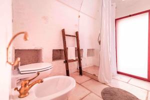 a white bathroom with a toilet and a sink at Masseria Spina Resort in Monopoli