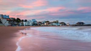a view of a beach with buildings in the background at The Crown Bar & Guesthouse in Broadstairs
