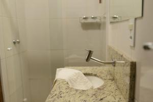a bathroom with a sink and a shower at Pousada Betânia in Curitiba