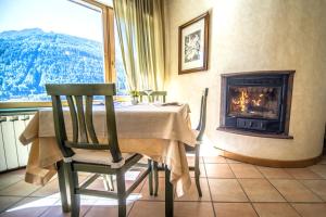 a dining room with a table and a fireplace at Hotel Veduta dell'Adamello in Temù